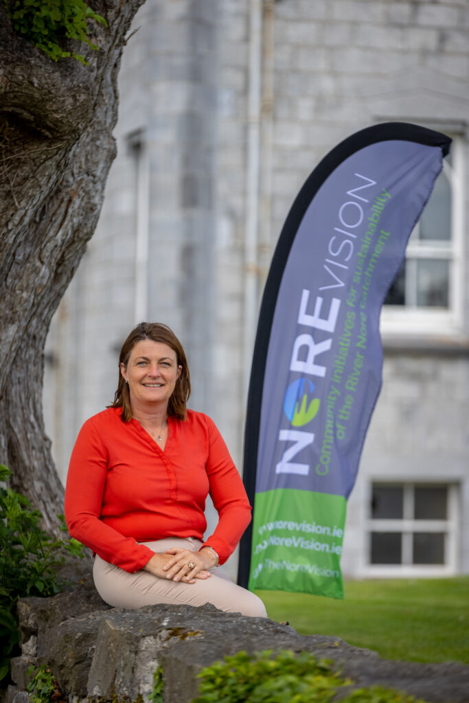 Ann Marie McSorley poses in front of a banner for the Biodiversity Initiative NoreVision